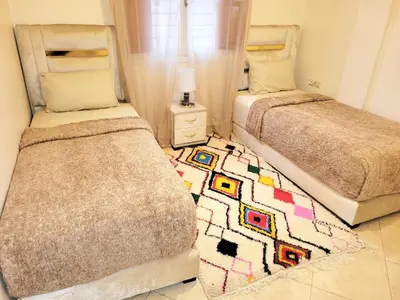 a bedroom with two beds and a rug on the floor at Authentic stay 2 in Marrakech Comfort & Charm in Marrakech