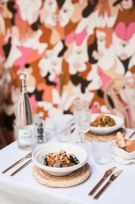 a table with plates of food and a bottle of wine at Le Singe Rose & SPA in Marrakech