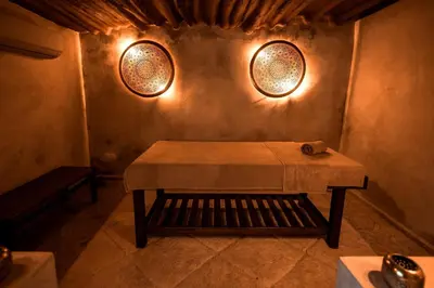 a table in a room with two lights on the wall at Le Singe Rose & SPA in Marrakech