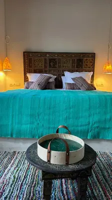 a bedroom with a bed with a turquoise blanket at Riad des Sources in Marrakech