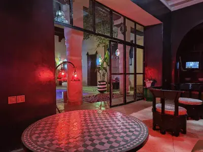 a red room with a table and some glass doors at Riad Palais Bahia - Entire House - 5 Bedrooms in Marrakech