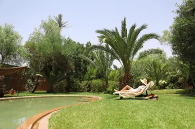 a woman laying in a lawn chair next to a pool at Villa Le Perroquet Bleu in Marrakech