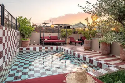 a patio with a pool with a table and chairs at Riad Tassili Boutique in Marrakech