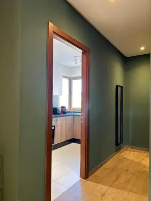 an open door to a kitchen with green walls at Exceptional Golf View Apartment, Prestigia in Marrakech