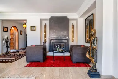 a living room with two chairs and a fireplace at Villa Simari Palmeraie Marrakech NOUVEAU! Petit déjeuner compris-Entièrement rénovée-Superbe piscine privée chauffée-Personnel de maison inclus-Grand jardin de 2000m2-Terrain de pétanque-Ambiance typique berbère-Havre de paix in Marrakech