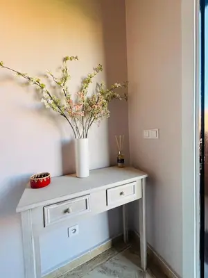 a white console table with a vase of flowers on it at Dar Sawan - Beautiful 2rooms & terrace at Atlas golf Palmeraie in Marrakech