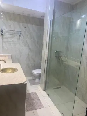 a bathroom with a glass shower and a toilet at beautiful appartment Premium village in Marrakech