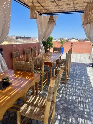 a row of tables and chairs on a patio at Riad dar lakbira in Marrakech