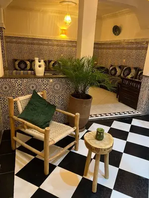 a living room with a chair and a table at Riad dar lakbira in Marrakech
