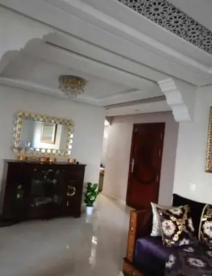 a living room with a couch and a mirror at appartement meuble in Marrakech