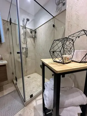 a shower stall in a bathroom with a table and a counter at City Haven at Pearl Garden Pool and View in Marrakech