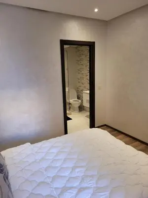 a bedroom with a bed and a bathroom with a toilet at Sublime appartement au coeur de Marrakech in Marrakech