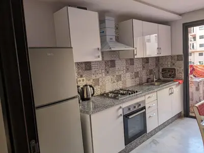 a kitchen with white cabinets and a refrigerator at Sublime appartement au coeur de Marrakech in Marrakech