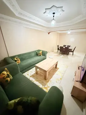 a living room with a green couch and a coffee table at Appartement Spacieux A Majorelle in Marrakech