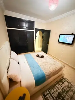 a bedroom with a bed and a flat screen tv at Appartement Spacieux A Majorelle in Marrakech