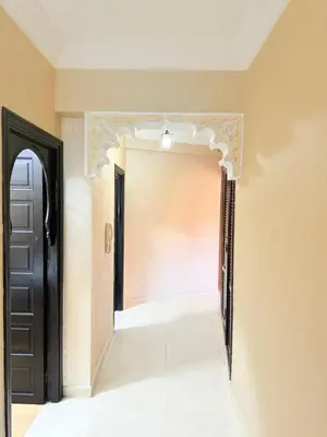 a hallway with a black door and a white tile floor at Appartement Spacieux A Majorelle in Marrakech
