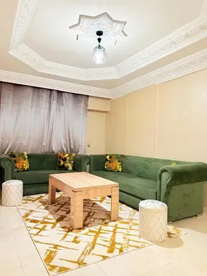 a living room with a green couch and a coffee table at Appartement Spacieux A Majorelle in Marrakech
