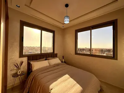 a bedroom with a large bed with two windows at New and modern apartment in Marrakech