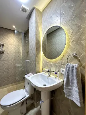 a bathroom with a toilet and a sink and a mirror at New and modern apartment in Marrakech