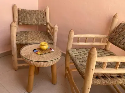 a table and two chairs and a yellow vase on a table at Location appartement a Marrakech aboib gulez in Marrakech