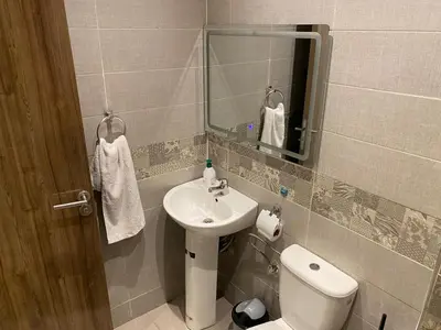 a bathroom with a sink and a toilet and a mirror at Location appartement a Marrakech aboib gulez in Marrakech