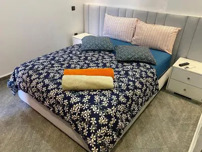 a bedroom with a bed with a blue comforter and pillows at Location appartement a Marrakech aboib gulez in Marrakech