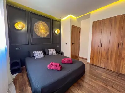 a bedroom with a bed with two pink pillows on it at Royal CinemaBedroom Gueliz Center in Marrakech
