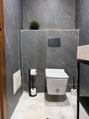 a bathroom with a toilet and a tile wall at Royal CinemaBedroom Gueliz Center in Marrakech
