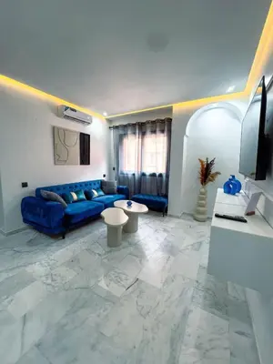 a living room with a blue couch and a tv at Royal CinemaBedroom Gueliz Center in Marrakech