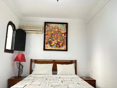a bedroom with a bed and a painting on the wall at LOGEMENT ENTIER MARRAKECh G26 N 35 in Marrakech