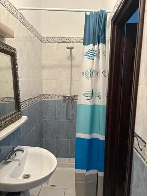 a bathroom with a shower curtain and a sink at LOGEMENT ENTIER MARRAKECh G26 N 35 in Marrakech