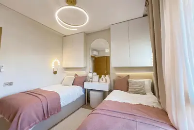 a bedroom with two beds and a sink and a mirror at Prestigia Saphir Luxury 3 Bedrooms, Pool & Golf View, near Airport in Marrakech