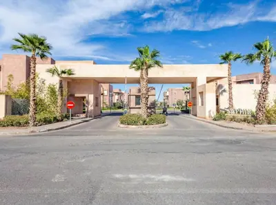an empty street in front of a building with palm trees at Prestigia Saphir Luxury 3 Bedrooms, Pool & Golf View, near Airport in Marrakech