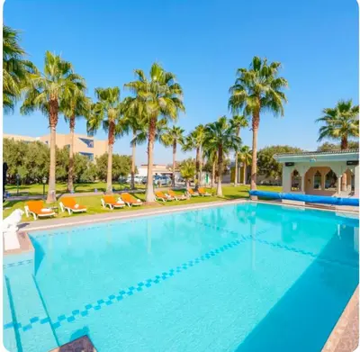 a large swimming pool with palm trees and chairs at Palais Rhize targa in Marrakech