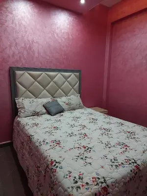 a bedroom with a bed with a floral bedspread at Furnished apartment close to the city center in Marrakech