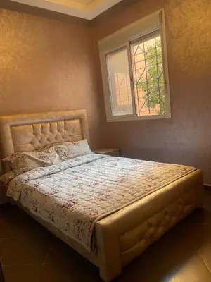 a bed in a bedroom with a window at Furnished apartment close to the city center in Marrakech