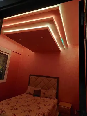 a bedroom with a bed with lights on the ceiling at Furnished apartment close to the city center in Marrakech