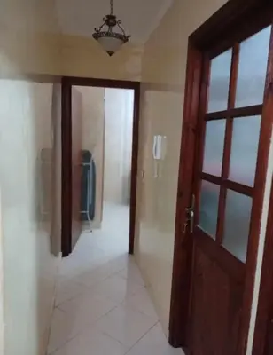 an empty hallway with a door and a room with a window at appartement meuble in Marrakech