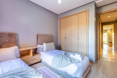 a bedroom with two beds and a closet at Waterfront - Garden Level - Prestigia in Marrakech