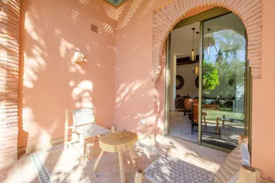a room with a table and chairs on a patio at Luxe et Detente Haut standing Piscine in Marrakech
