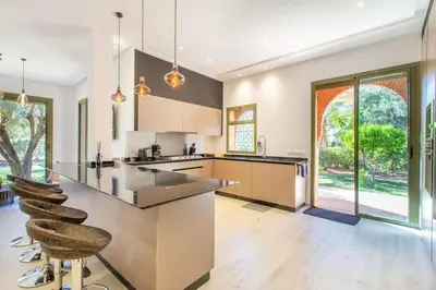 an open kitchen with a large island with bar stools at Luxe et Detente Haut standing Piscine in Marrakech