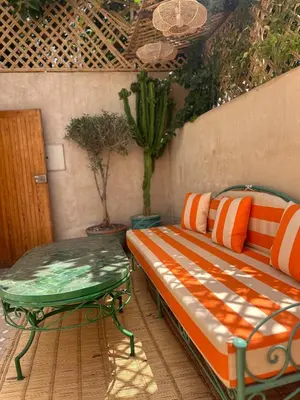 a bench and a table on a patio at Riad Dar Chalyia, private, 6 people, pool in Marrakech