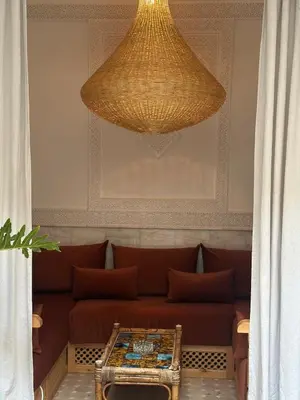 a large chandelier hanging over a couch in a room at Riad Dar Chalyia, private, 6 people, pool in Marrakech