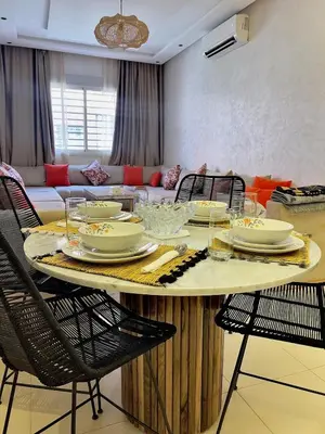 a dining room table with chairs and a couch at Family Apartment in Marrakech in Marrakech