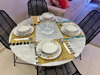 a table with plates and glasses on top of it at Family Apartment in Marrakech in Marrakech