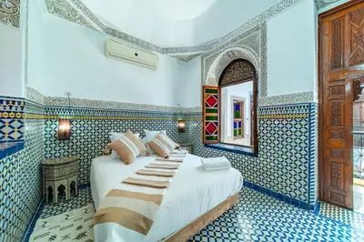 a bedroom with a bed in a room with blue tiles at Riad Khadoj-Marrakech-Traditional in Marrakech