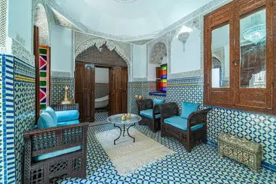 a living room with blue chairs and a table at Riad Khadoj-Marrakech-Traditional in Marrakech