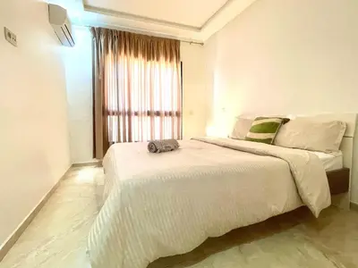a bedroom with a large bed and a window at luxury Aprt2-bedrooms Pool hivernage heart of city in Marrakech