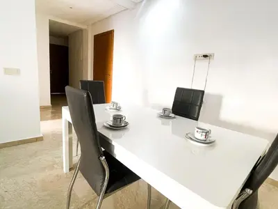 a white table and chairs with cups and plates on it at luxury Aprt2-bedrooms Pool hivernage heart of city in Marrakech