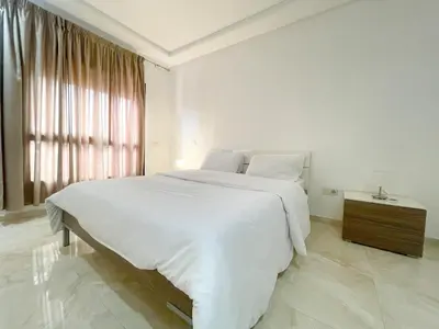 a white bedroom with a large bed and a window at luxury Aprt2-bedrooms Pool hivernage heart of city in Marrakech